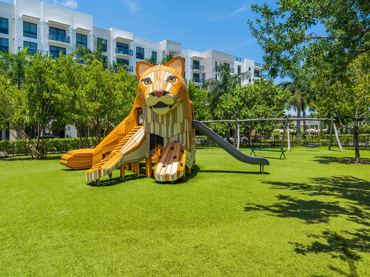 A playground with a slide shaped like a lion's head.
